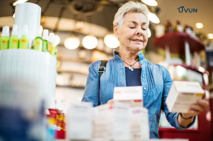 Idosa analisando medicamentos na farmácia para conseguir remédio de graça pelo programa federal.