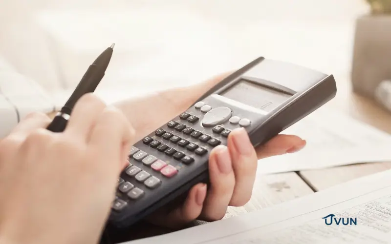 Pessoa usando calculadora para organizar dívidas e analisar opções do Desenrola Brasil.