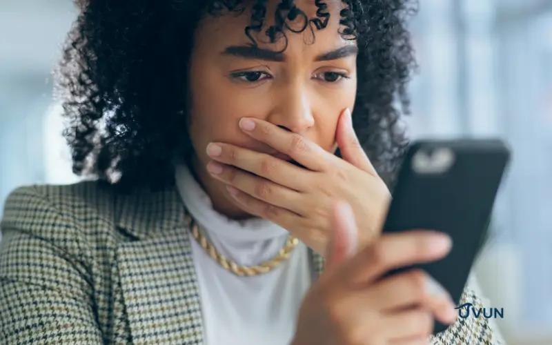 Femme inquiète face aux arnaques financières sur son téléphone