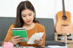 Femme vérifiant ses dépenses face à un découvert bancaire.